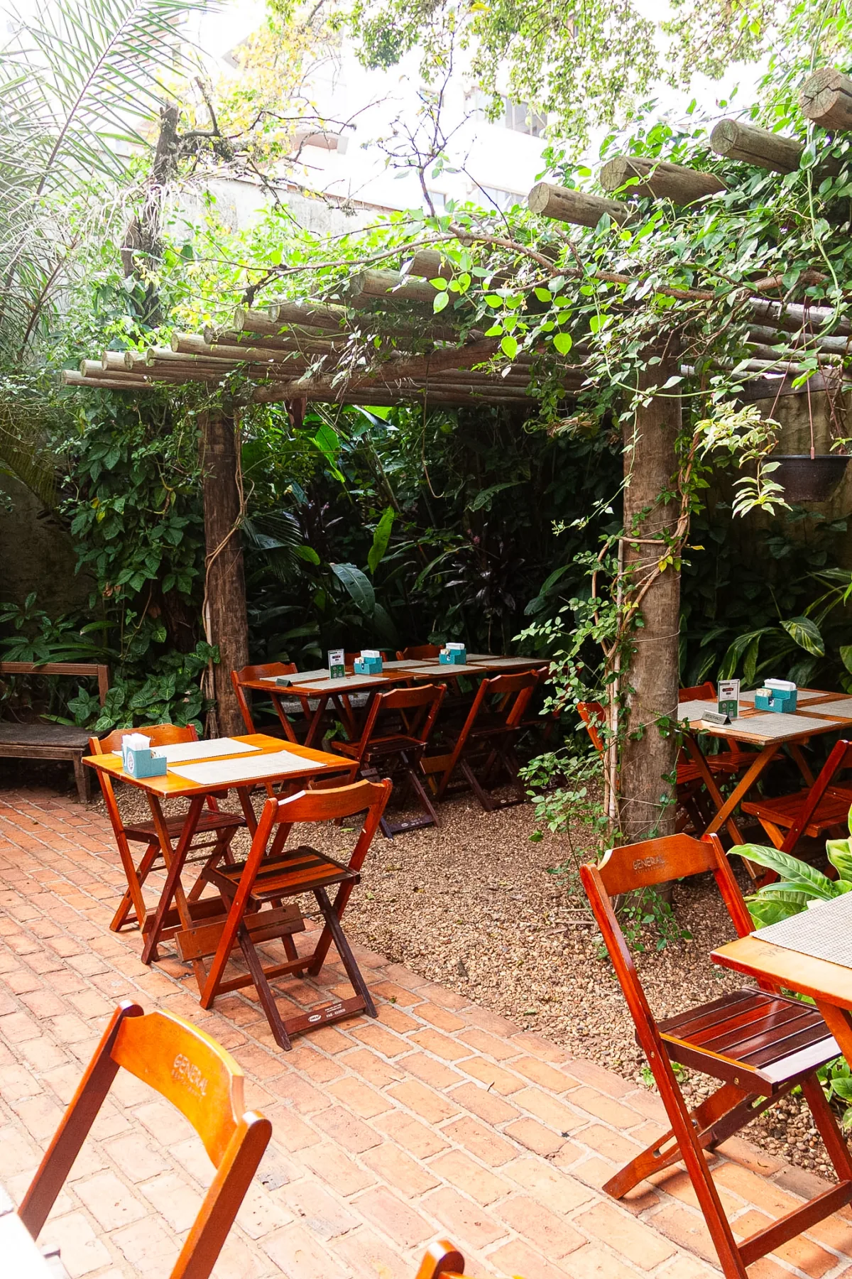 Jardim com pergolado e mesas do Restaurante General